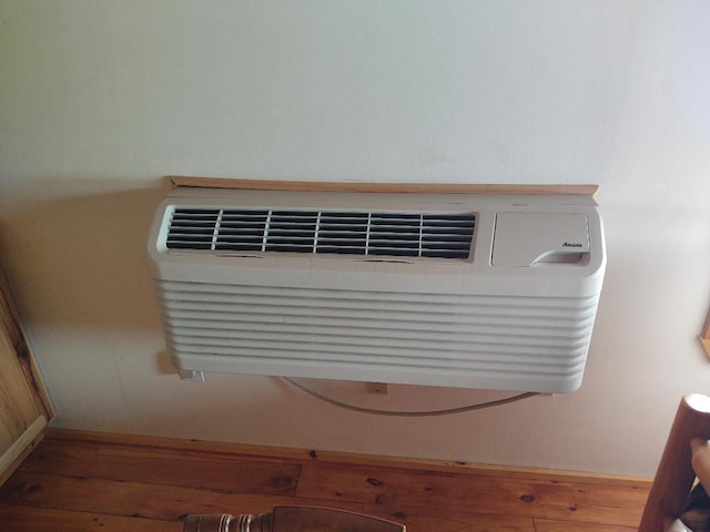 interior details featuring hardwood / wood-style flooring and a wall mounted AC