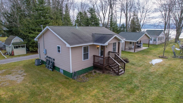 view of front of home featuring central AC unit, a front lawn, and an outdoor structure