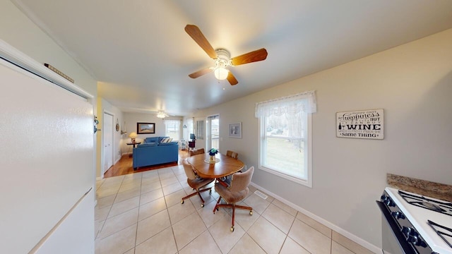 dining space featuring light tile patterned floors and ceiling fan