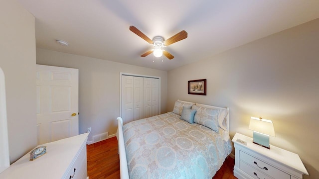 bedroom featuring dark hardwood / wood-style flooring, a closet, and ceiling fan