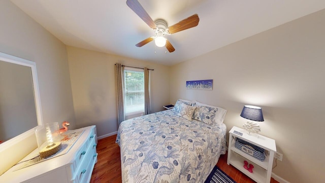 bedroom with heating unit, ceiling fan, and dark hardwood / wood-style floors