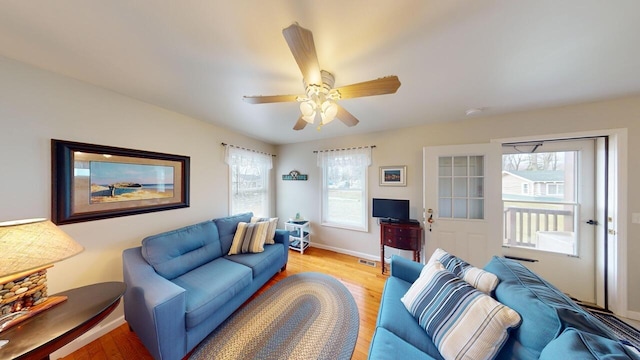 living room with ceiling fan and light hardwood / wood-style flooring