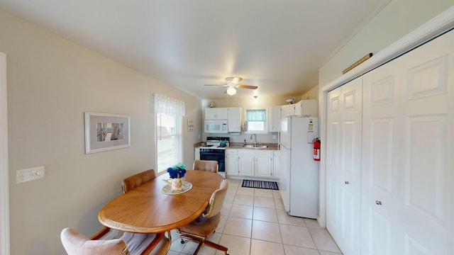 tiled dining area with ceiling fan and sink