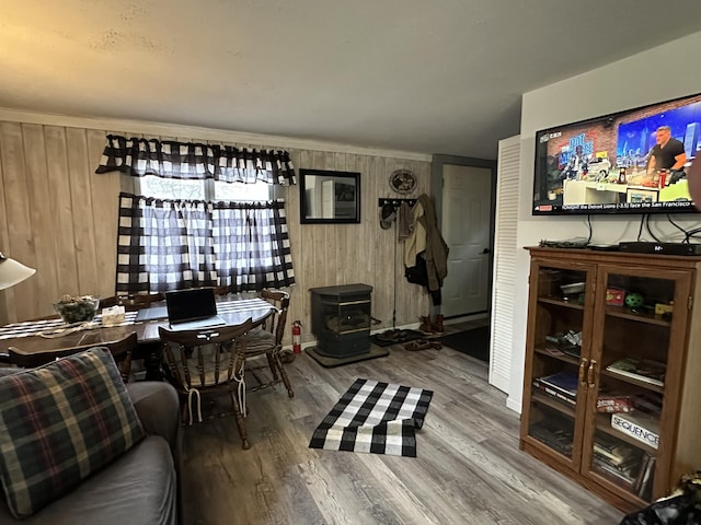 interior space featuring hardwood / wood-style flooring, a wood stove, and wooden walls