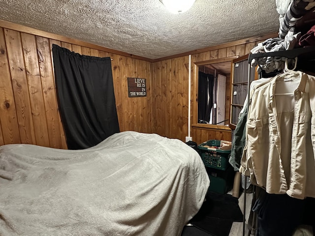 bedroom featuring wood walls and a textured ceiling