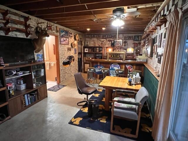 home office with ceiling fan and concrete floors