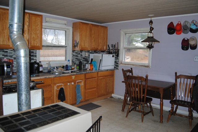 kitchen with pendant lighting, tasteful backsplash, ornamental molding, and sink