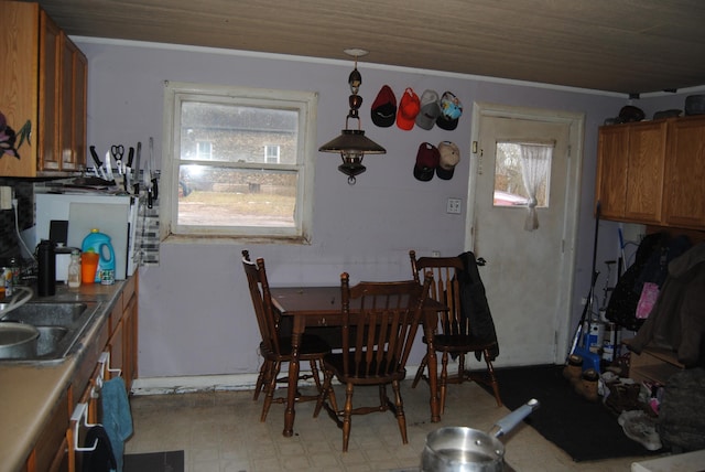 dining area with crown molding, sink, and wood ceiling