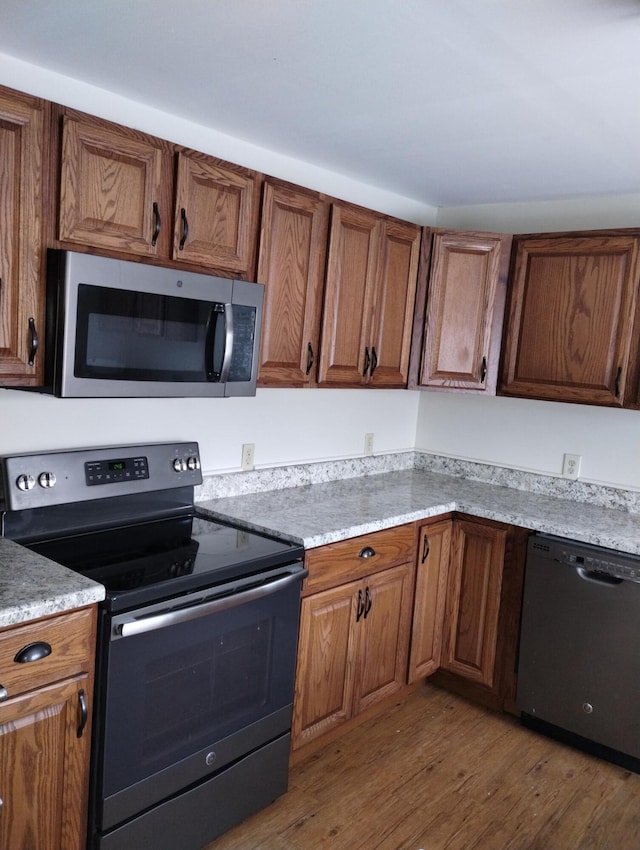 kitchen with hardwood / wood-style floors and stainless steel appliances