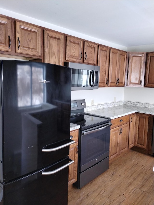 kitchen with black appliances and light wood-type flooring