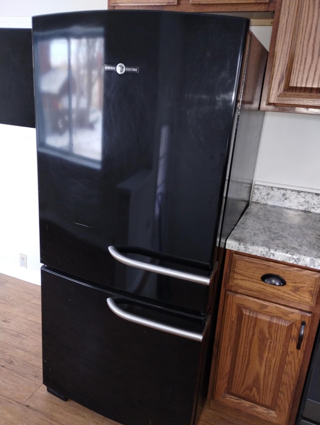 details featuring black refrigerator and light hardwood / wood-style floors