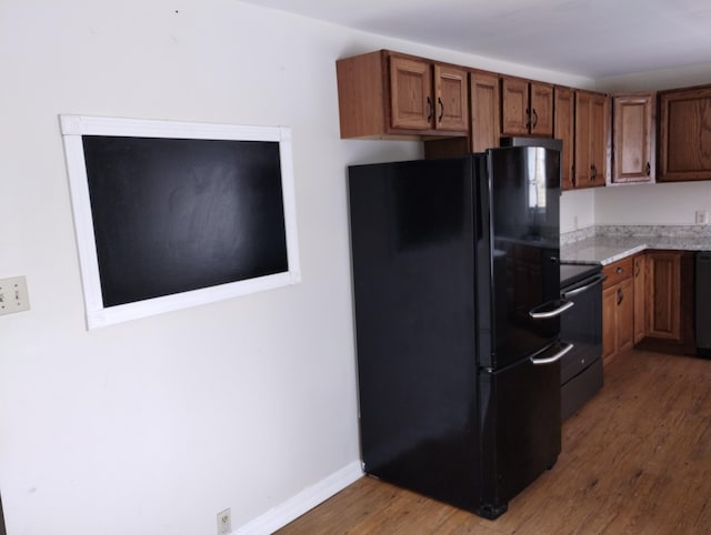 kitchen with black appliances and dark hardwood / wood-style floors