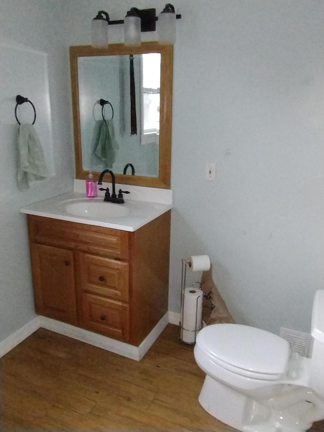 bathroom featuring hardwood / wood-style floors, vanity, and toilet