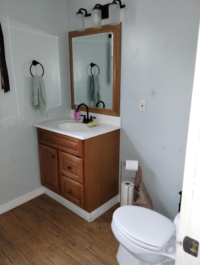 bathroom featuring hardwood / wood-style floors, vanity, and toilet