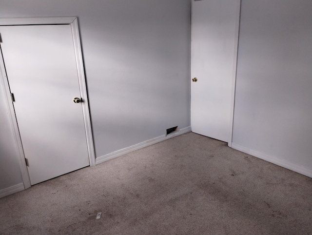 unfurnished bedroom featuring a closet and light colored carpet