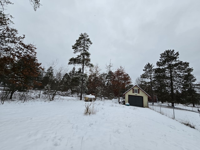 yard covered in snow with an outbuilding and a garage