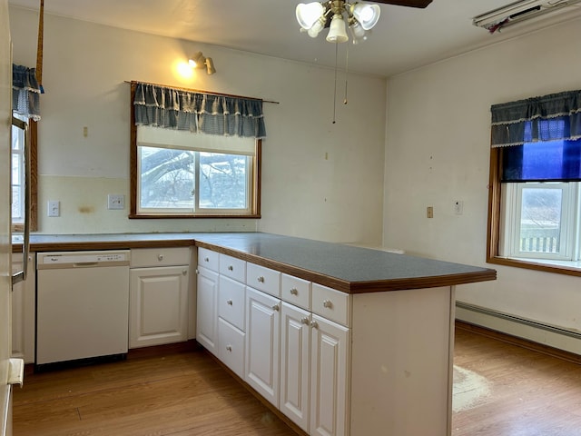 kitchen with white dishwasher, kitchen peninsula, ceiling fan, light wood-type flooring, and white cabinetry