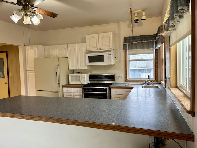 kitchen with kitchen peninsula, white appliances, ceiling fan, sink, and white cabinets