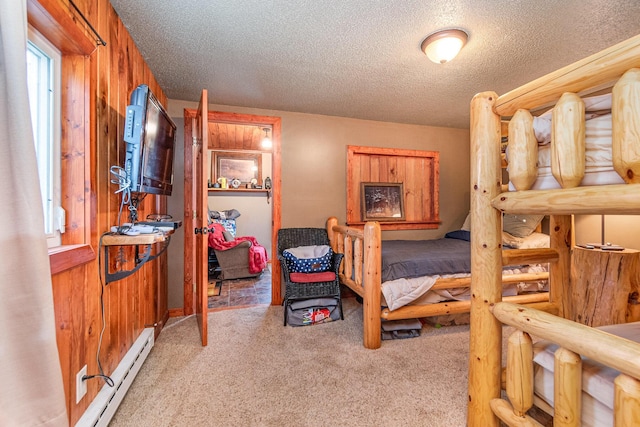 bedroom with a textured ceiling, light colored carpet, baseboard heating, and wooden walls