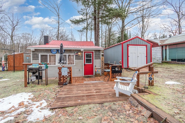 back of house with a shed and a wooden deck