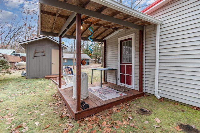 wooden terrace with a storage shed and a lawn