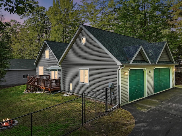 exterior space with a lawn, a garage, and a deck