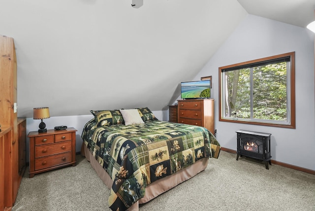 carpeted bedroom featuring a wood stove and lofted ceiling