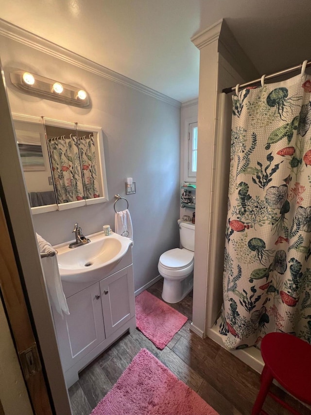 bathroom featuring walk in shower, vanity, crown molding, wood-type flooring, and toilet