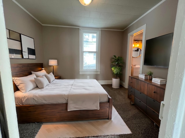 carpeted bedroom featuring ornamental molding and connected bathroom