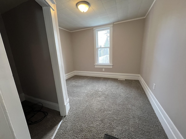 carpeted spare room featuring crown molding