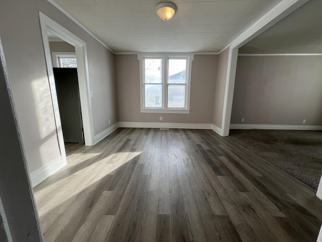 empty room with hardwood / wood-style flooring and crown molding