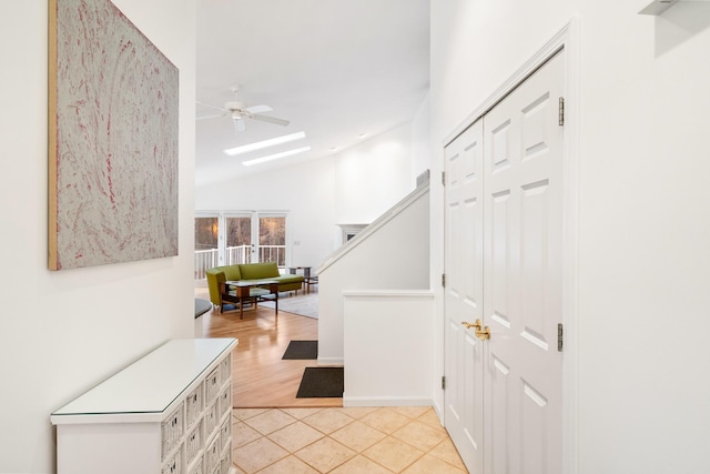 corridor featuring light tile patterned floors and vaulted ceiling