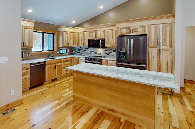 kitchen featuring light stone countertops, light brown cabinets, backsplash, and black appliances