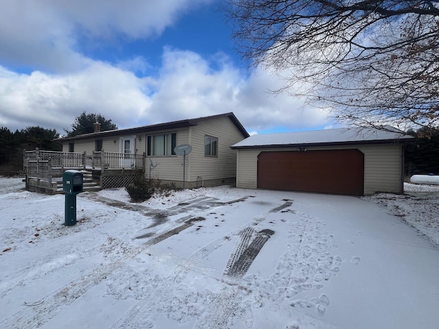 view of front of house featuring a garage, a deck, and an outbuilding