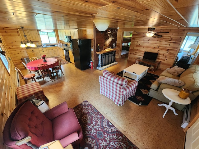 living room with wooden walls, ceiling fan, and wood ceiling