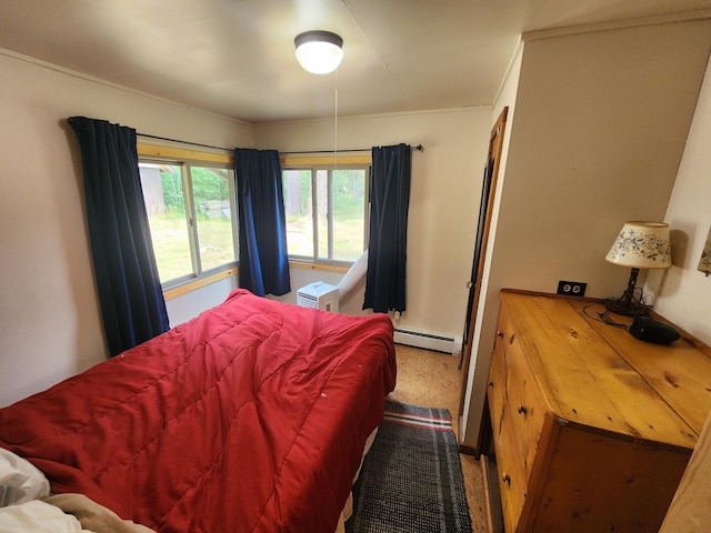 bedroom with ornamental molding and a baseboard heating unit