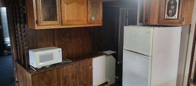 kitchen featuring white appliances and wooden walls