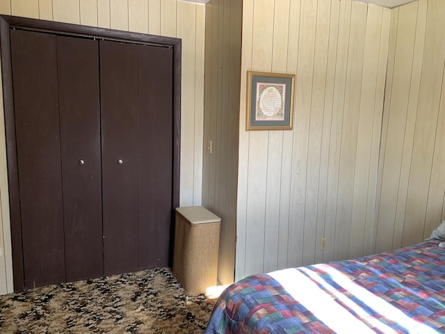 bedroom with a closet and wooden walls