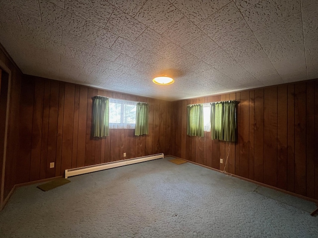 unfurnished room with wooden walls and a baseboard heating unit