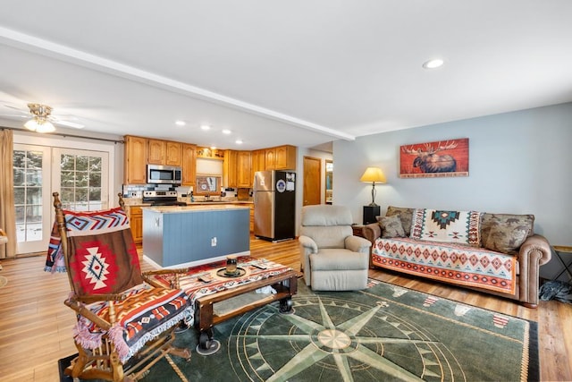 living room with ceiling fan, sink, light wood-type flooring, and french doors