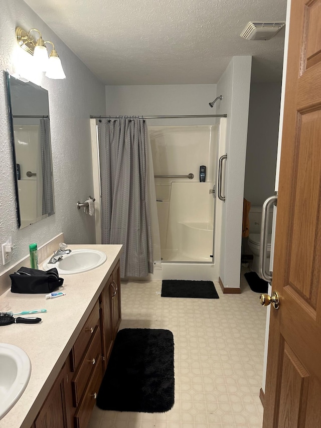 bathroom with toilet, vanity, a textured ceiling, and a shower with shower curtain