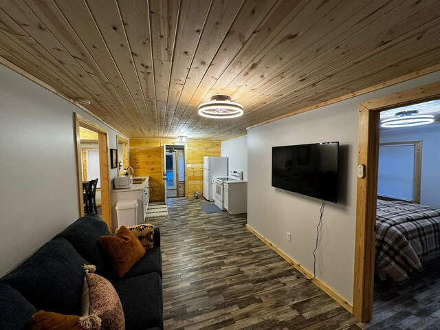 living room with wooden walls, sink, wooden ceiling, and dark hardwood / wood-style floors