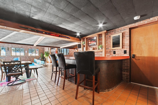 bar featuring tile patterned flooring and brick wall