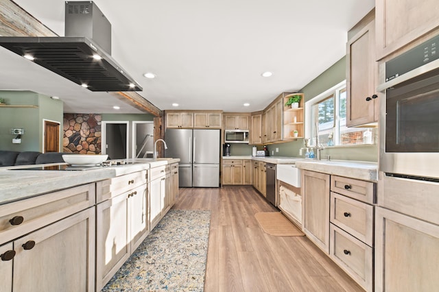 kitchen with light brown cabinets, exhaust hood, sink, light wood-type flooring, and stainless steel appliances