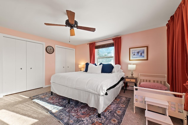 carpeted bedroom with two closets and ceiling fan