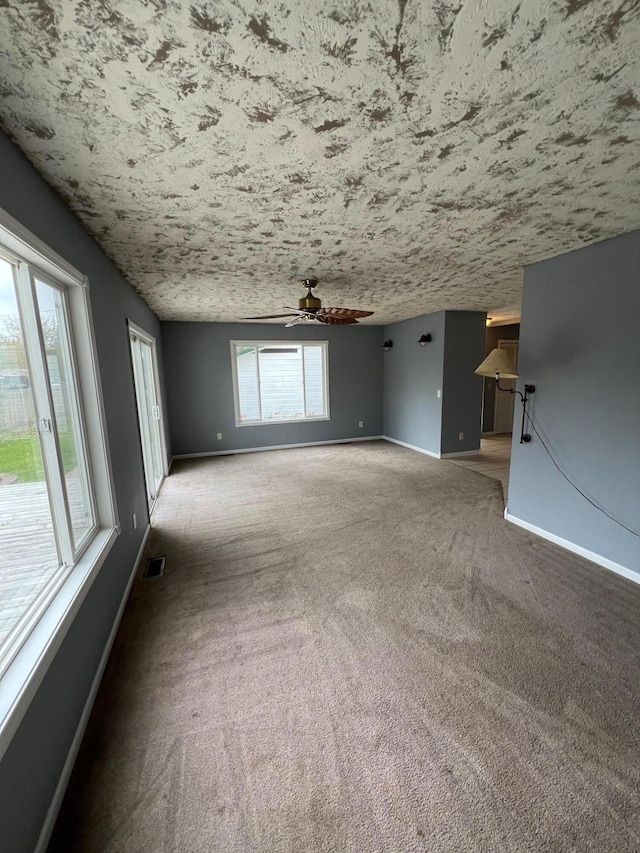 unfurnished living room with carpet and ceiling fan