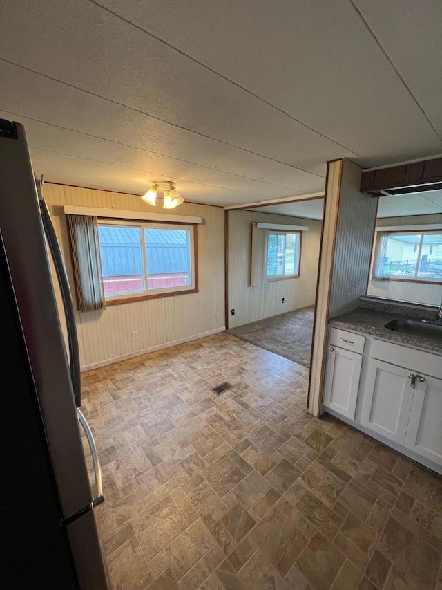 unfurnished dining area featuring wood walls and sink