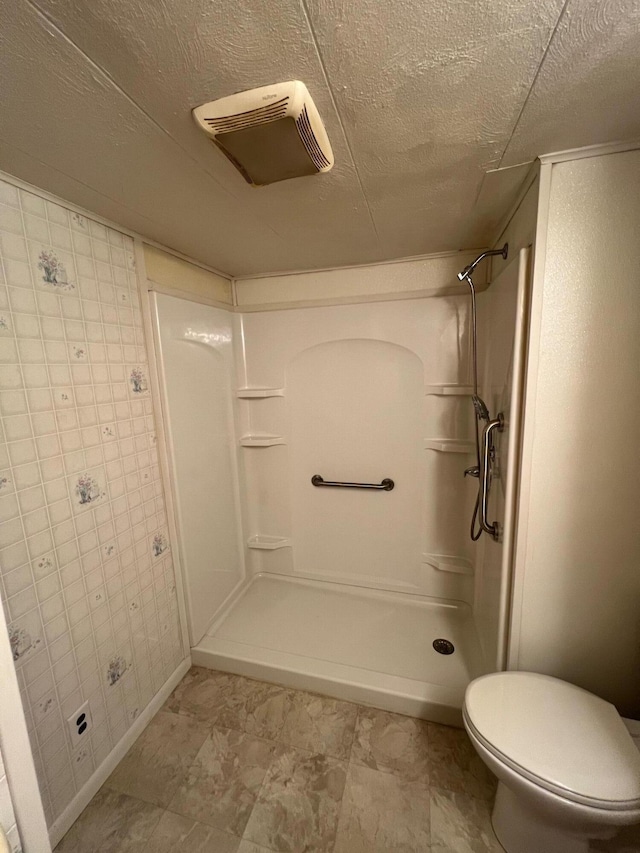 bathroom featuring walk in shower, a textured ceiling, and toilet