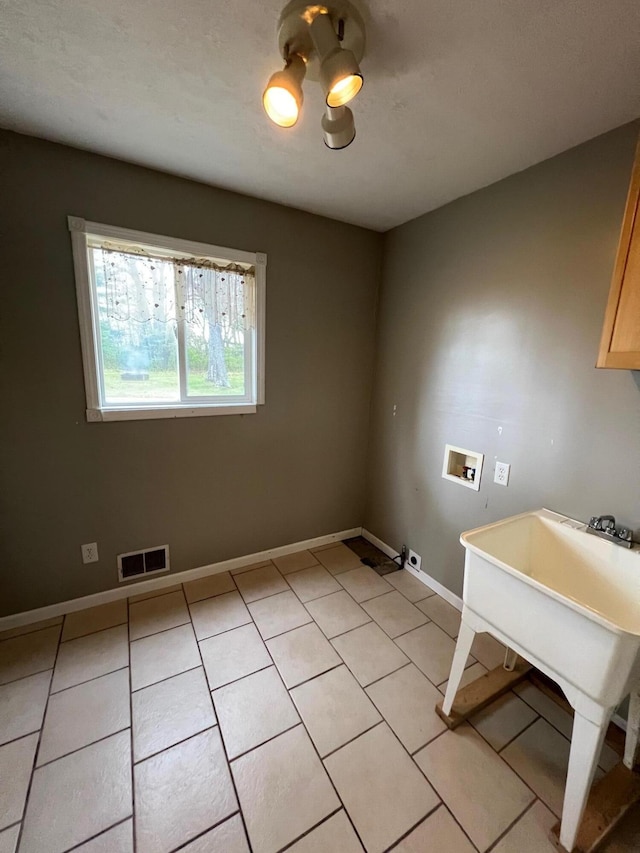 laundry room with cabinets, light tile patterned floors, and washer hookup