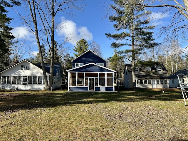 rear view of property featuring a yard and a sunroom